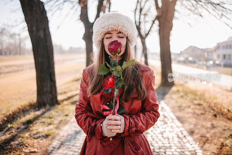 一个年轻的女人在闻玫瑰