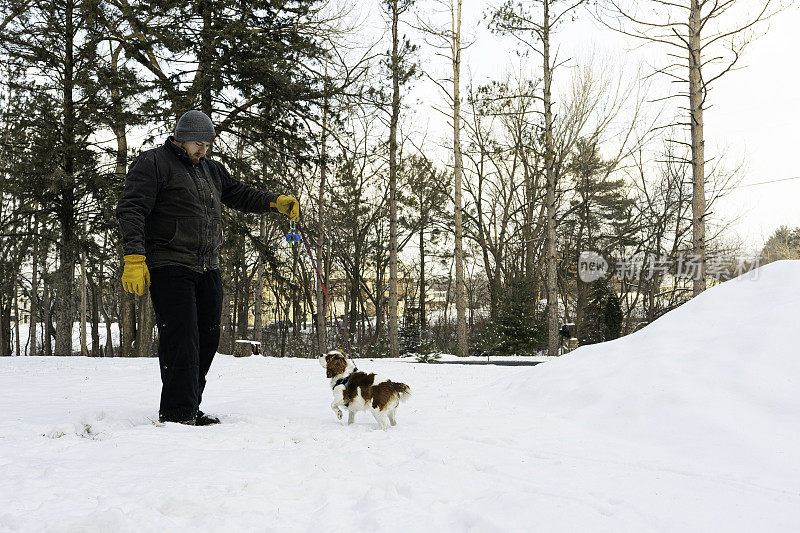 一个人带着他的狗在外面的雪地里