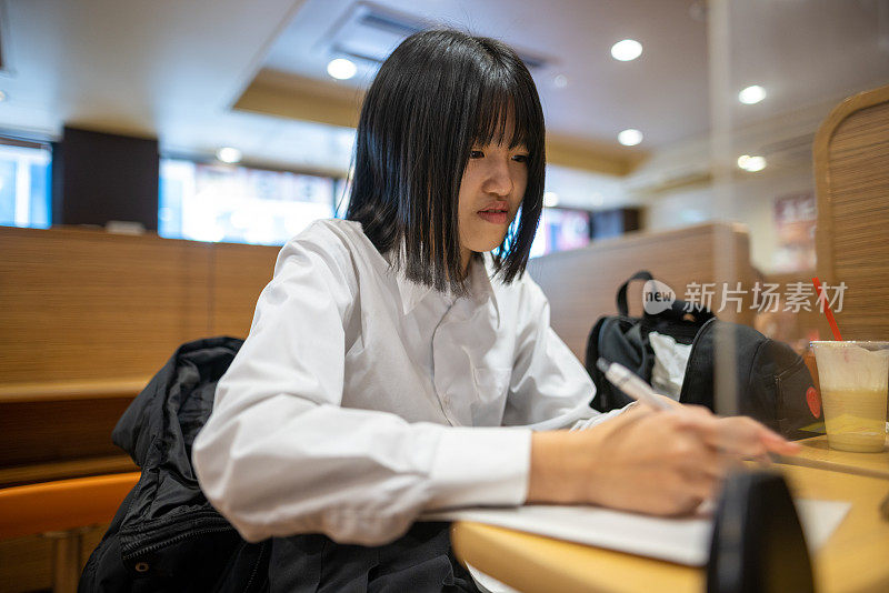 女学生在咖啡馆做作业