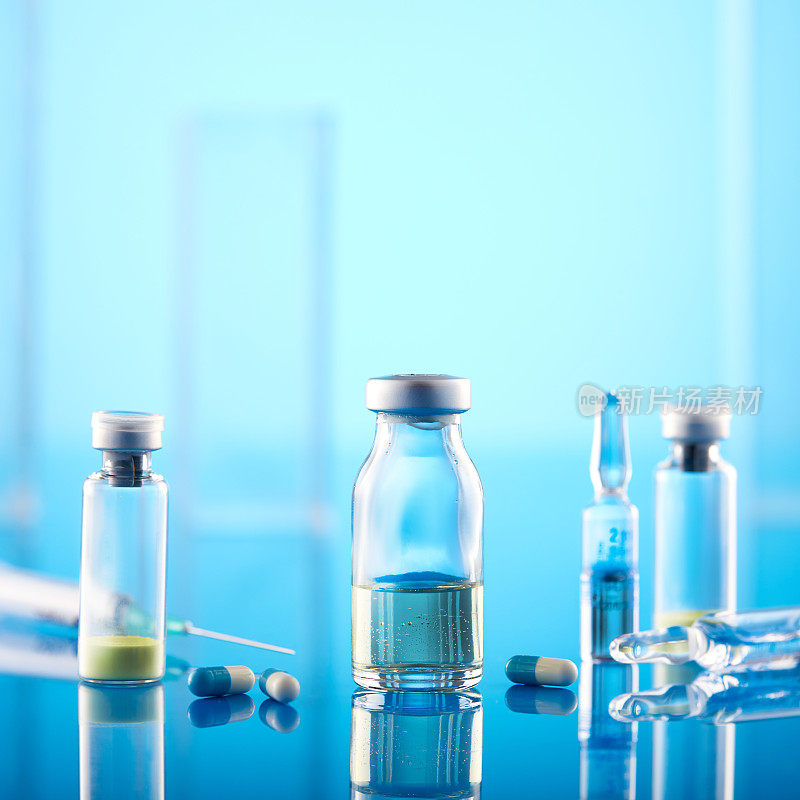 冠状病毒疫苗:蓝色背景的注射器和小瓶