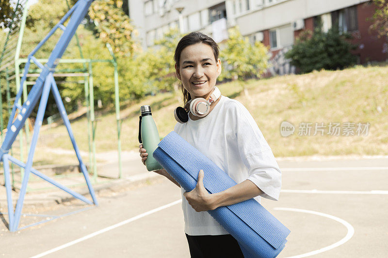 美丽的亚洲女人上户外瑜伽课