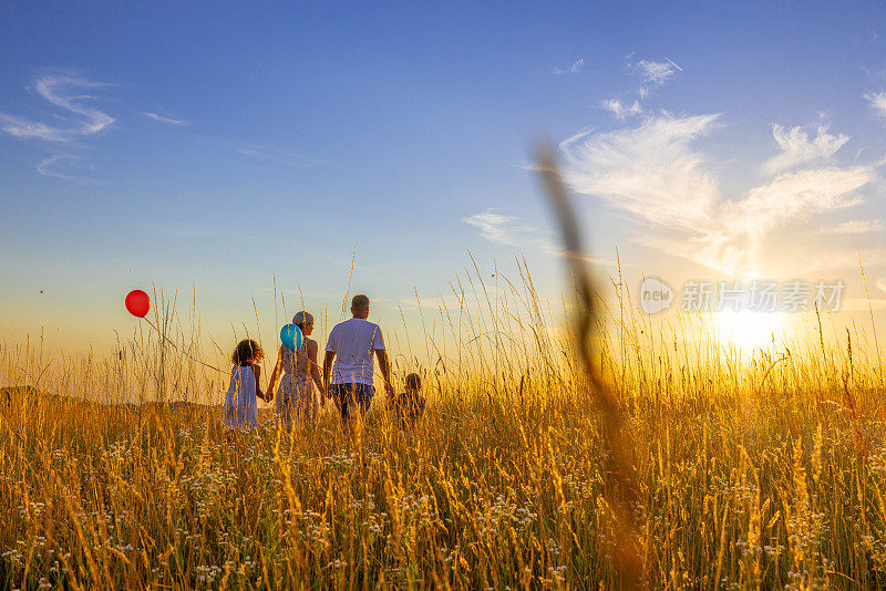 一家人在草地上散步，对着天空