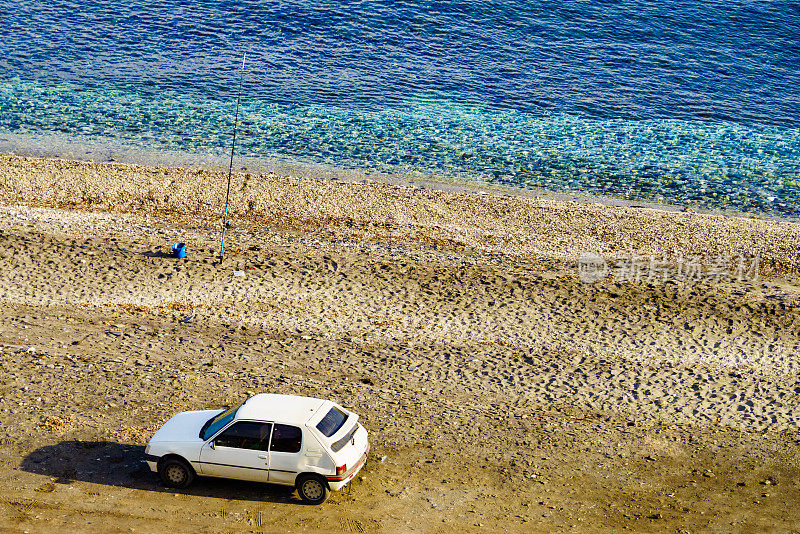 海边的汽车和鱼竿。
