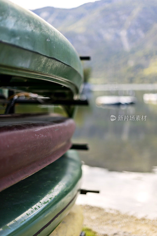 堆放在斯洛文尼亚博欣吉湖畔的独木舟，背景是朱利安阿尔卑斯山