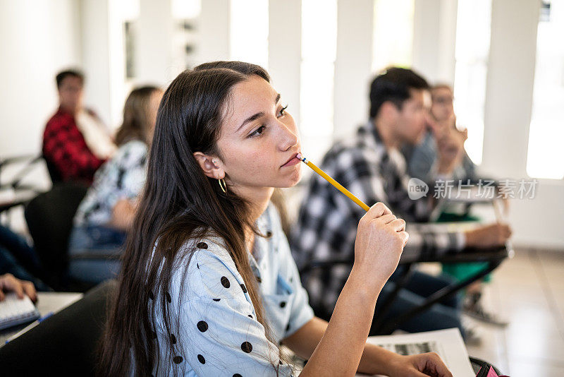 年轻女子在大学看课时思考