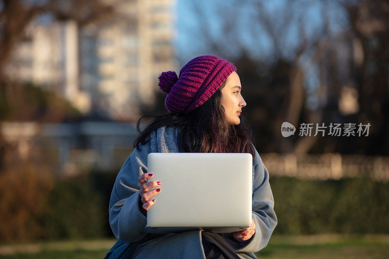 年轻的学生女孩正在外面学习。