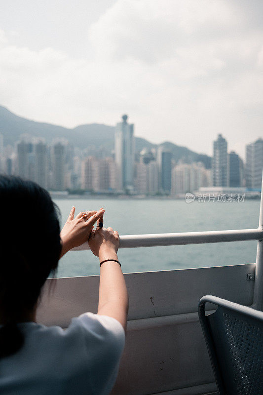 亚洲女孩乘坐渡轮去冒险，享受夏日的微风和景色