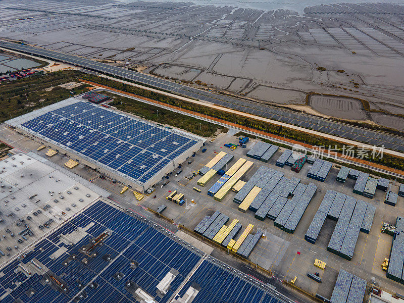 沿海工业厂房和道路屋顶新能源太阳能光伏发电鸟瞰图