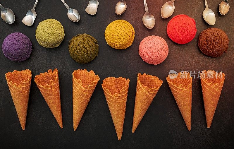 各种口味的冰淇淋蓝莓，开心果，杏仁，橘子，绿茶和巧克力设置在黑色的石头背景。夏日和甜蜜的菜单概念。