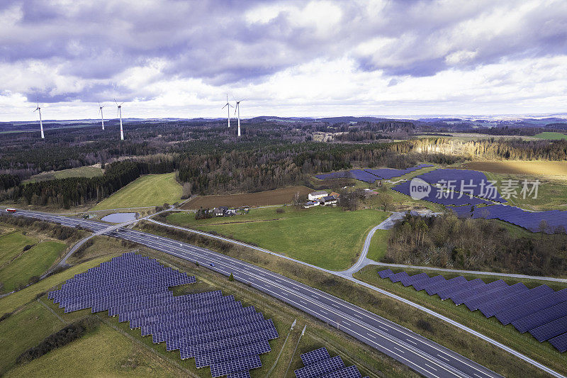 高速公路附近现代太阳能电池板和风力涡轮机的鸟瞰图
