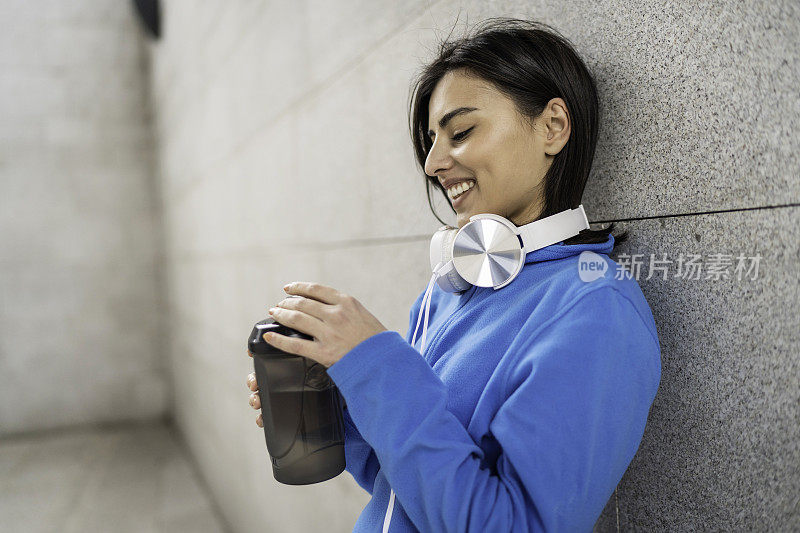 年轻女子在户外运动后喝水