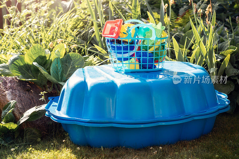 新塑料游泳池配有一套玩具，在花园的院子里