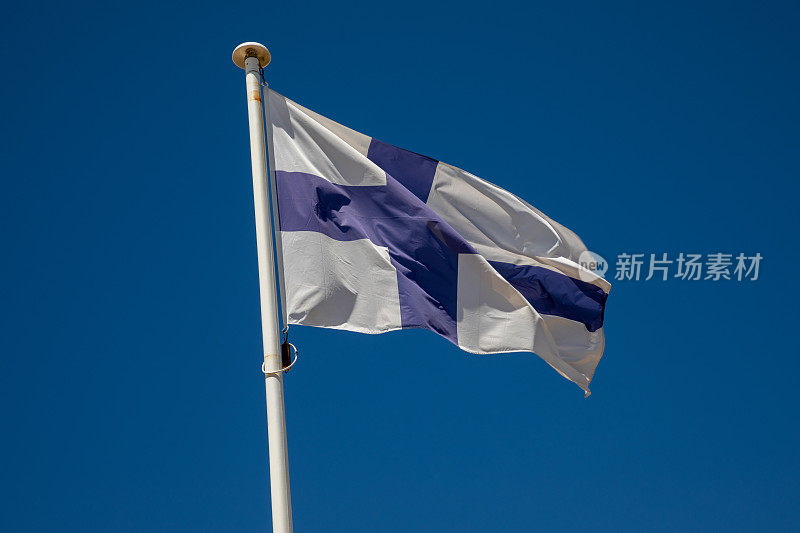 芬兰国旗芬兰国家国旗在风和蓝天的桅杆上