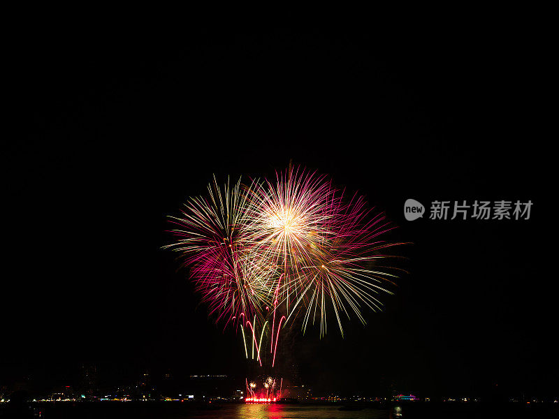 烟花夜空抽象黑色背景光旅行派对火新年快乐庆祝活动红橙色卡模拟假期效果光明亮河海场景，节日泰国芭堤雅。