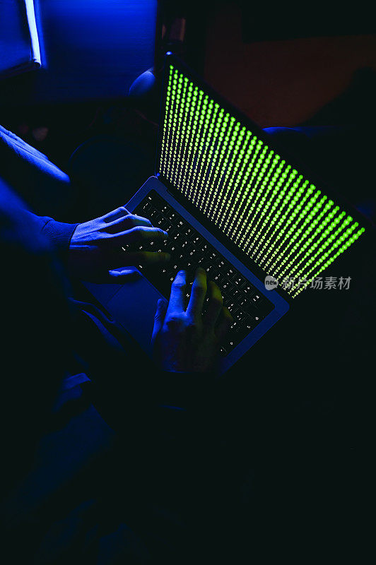 夜间黑客在笔记本电脑上编写代码的俯视图。
