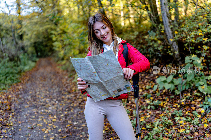 女人熟练地阅读地图，精心安排她的徒步旅行路线