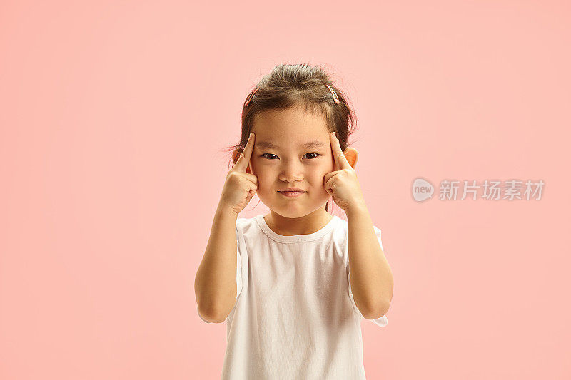 韩国少女皱着眉头表示高度专注或试图记住某事，用手指按压太阳穴，试图记住忘记的事情，表现出高度集中或精神紧张