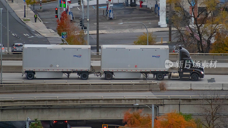 T-Force货运线运输半卡车在90号州际公路上向东行驶，穿过美国华盛顿州斯波坎市的市中心。