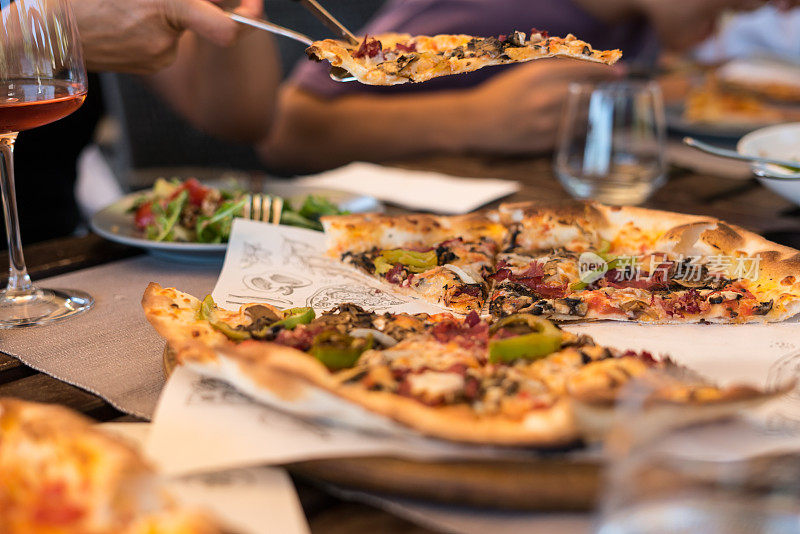 披萨是在桌子上的广告服务重点在前景水平照片披萨切片是服务