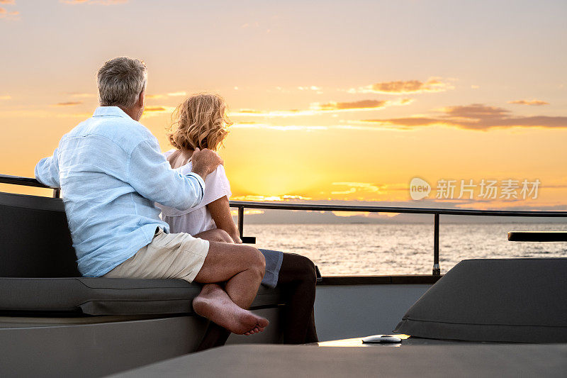 一对情侣在游艇甲板上享受浪漫的日落