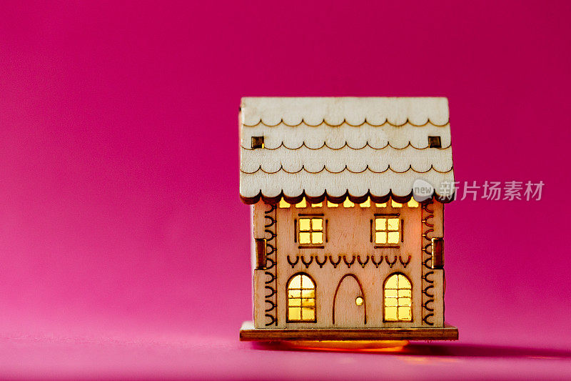 粉色背景的木制模型房子