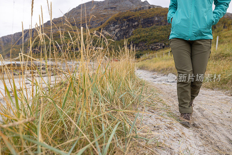 一位女性徒步旅行者在挪威海岸线的步道上的低角度照片