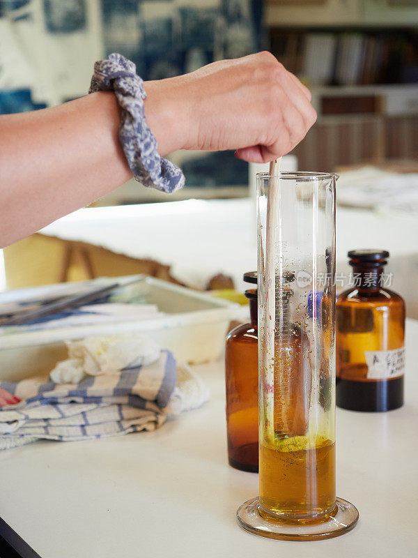 在实验室的玻璃试管中手工混合琥珀色化学液体