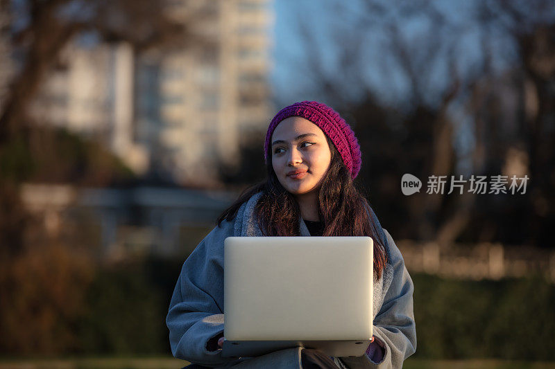 年轻的学生女孩正在外面学习。