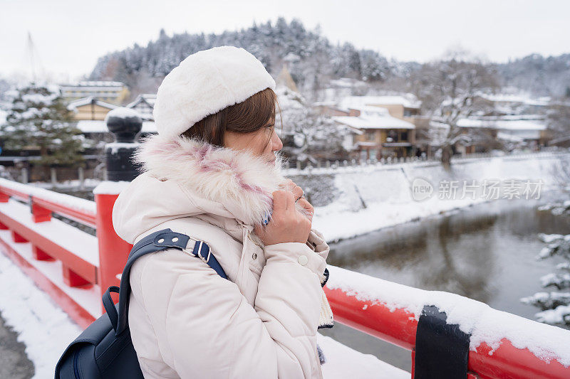 美丽的女子游客享受他们的日本之旅在雪的冬天。