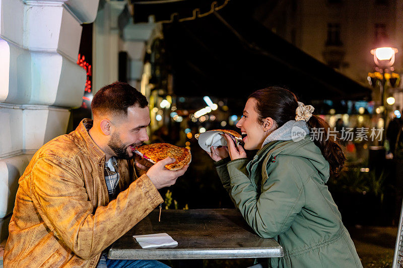 年轻夫妇在户外享受美味的披萨