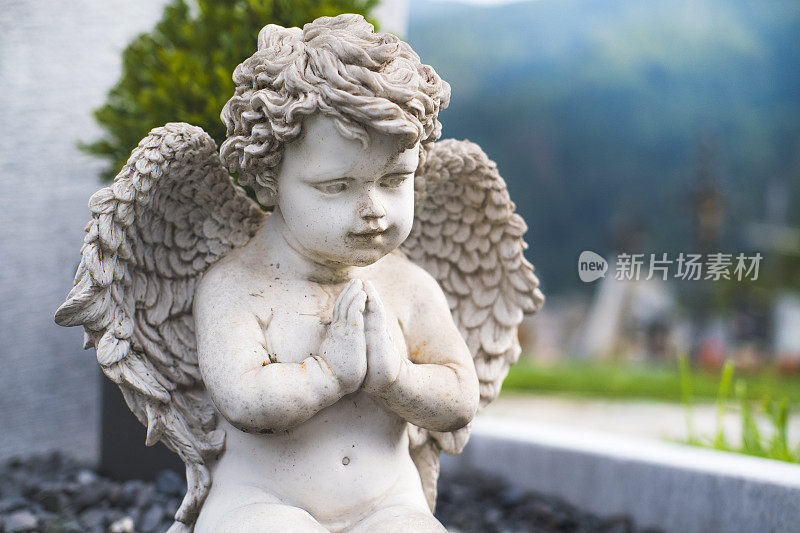 天使在坟墓上祈祷的雕像。