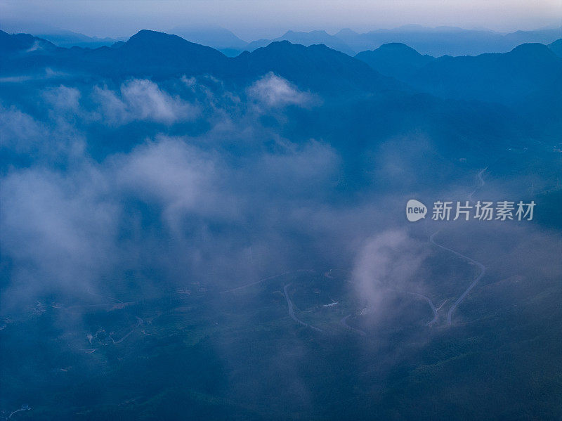 在蓝天白云的群山中俯瞰蜿蜒的道路