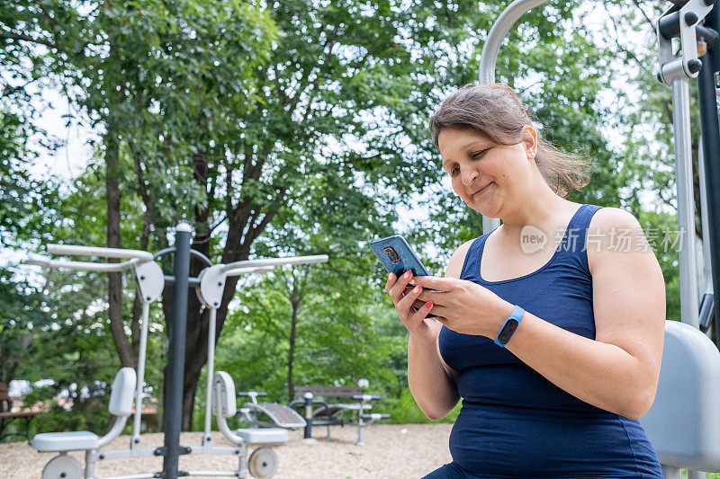 一个穿着运动服的年轻女子正在看她的手机。