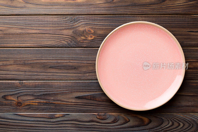 木制背景上的空粉红色板的顶视图。为你的设计留出空间