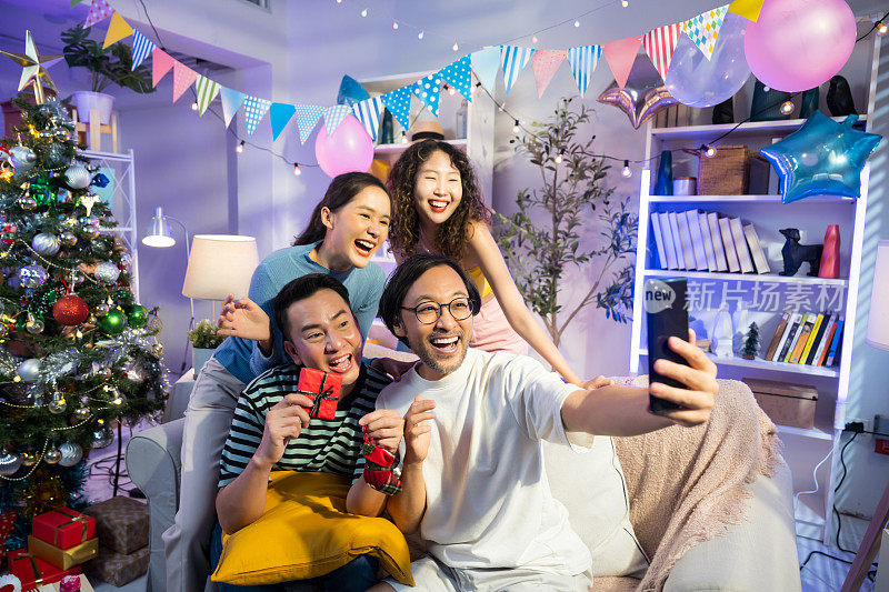 一群亚洲朋友一起在圣诞派对上自拍或视频通话