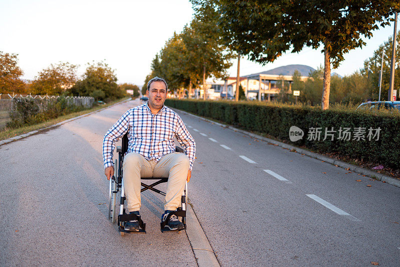 残疾白人中年男子，推着轮椅，在附近的人行道上