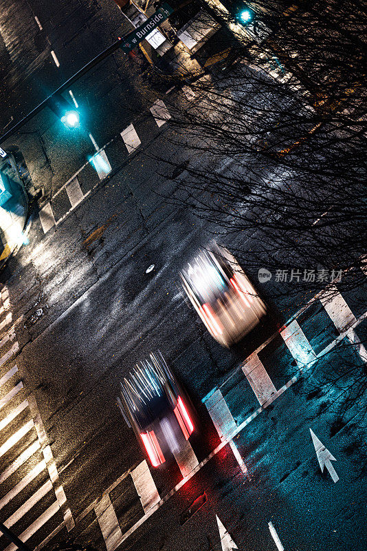 两辆车在夜晚潮湿的街道上飙车