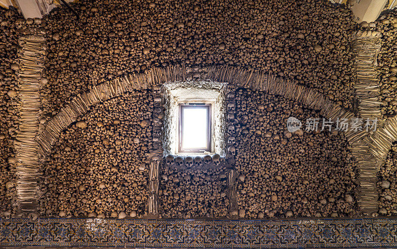 墙上装饰着堆叠的人类头骨和用骨头做成的拱门。教堂。埃武拉。葡萄牙。它是由三位方济各会修士倡议创建的。
