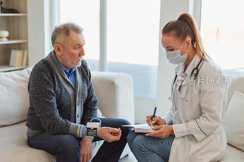 女医生年老的男子在医生办公室或在家里测量血压。老年病人和医生在病房里会诊。医药保健体检。去看医生。