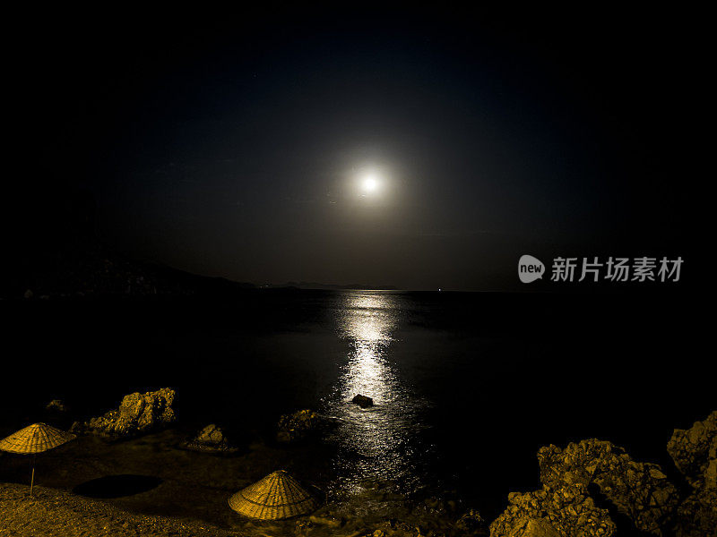 晚上把雨伞和躺椅放在海岸线旁边