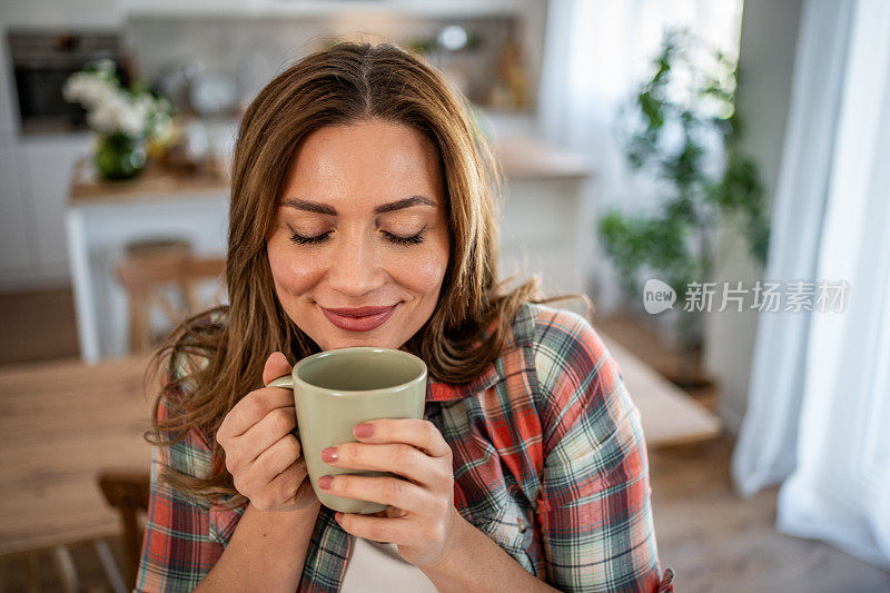 早晨舒缓的节奏——一位年轻女子在厨房里享受着早晨的咖啡