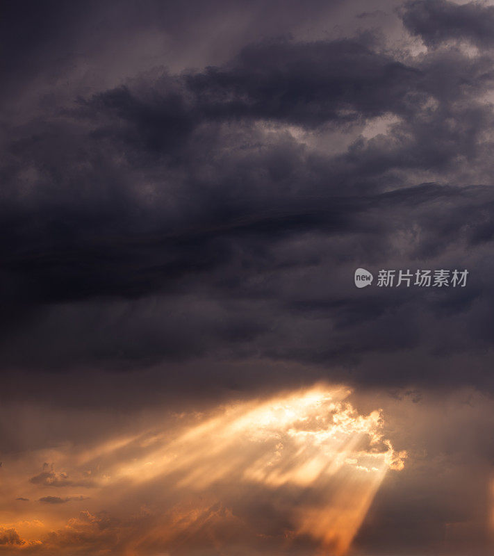 戏剧性的日落天空背景:阳光穿透黑色雷云