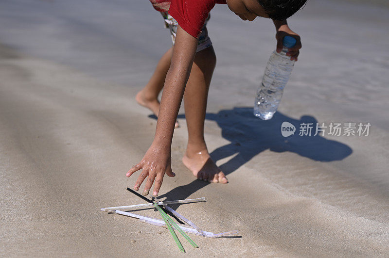 在海滩捡塑料吸管