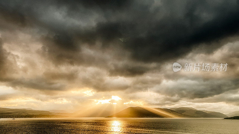 黄昏的光线穿透云层，苏格兰阿盖尔山。