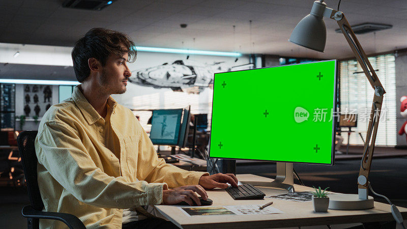 白人男子使用桌面电脑模拟绿屏Chromakey。在游戏设计公司工作的男性概念美工，为新的冒险电子游戏创造身临其境的游戏玩法。