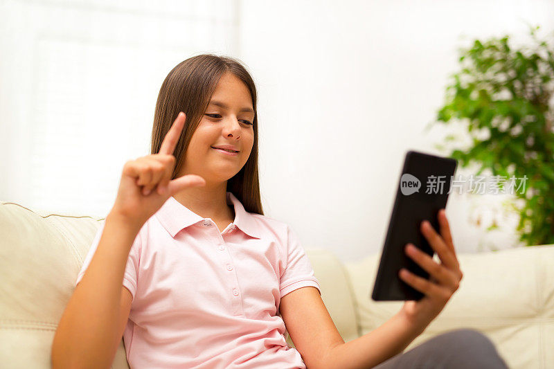 微笑的聋哑女孩在数字平板电脑上用手语交谈