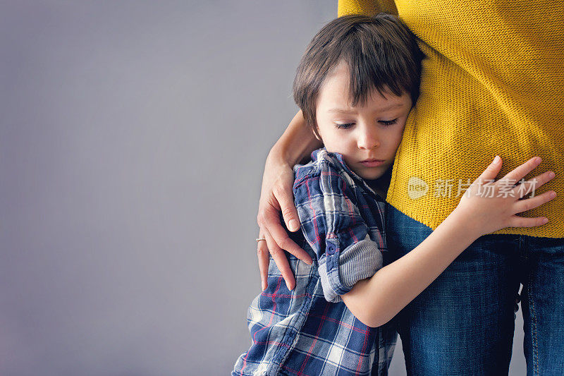 可怜的小男孩，在家里拥抱他的妈妈