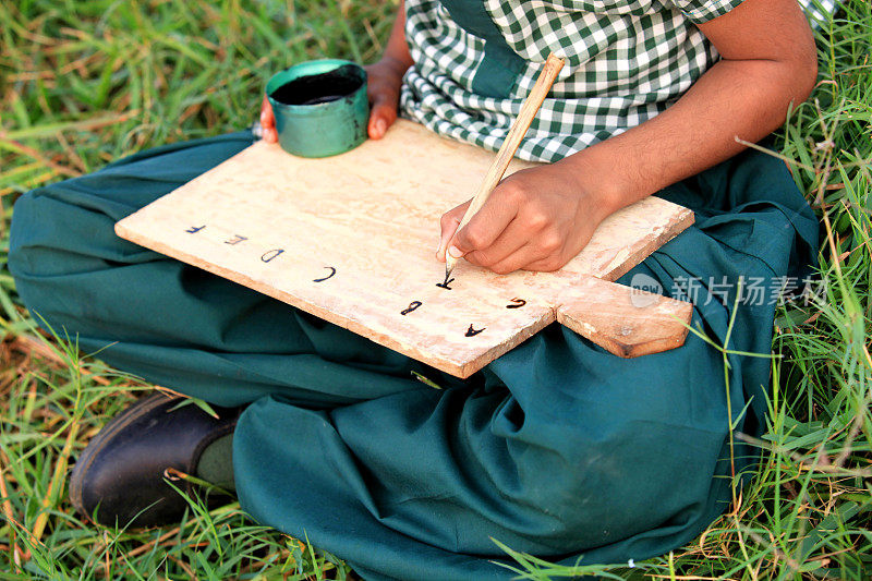 小女孩坐在田野里写作