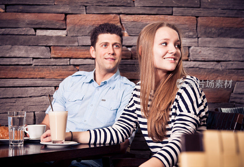 一对年轻夫妇坐在咖啡馆里
