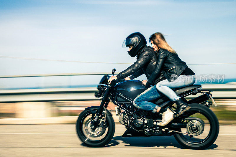 一对夫妇骑着一辆快速的摩托车旅行
